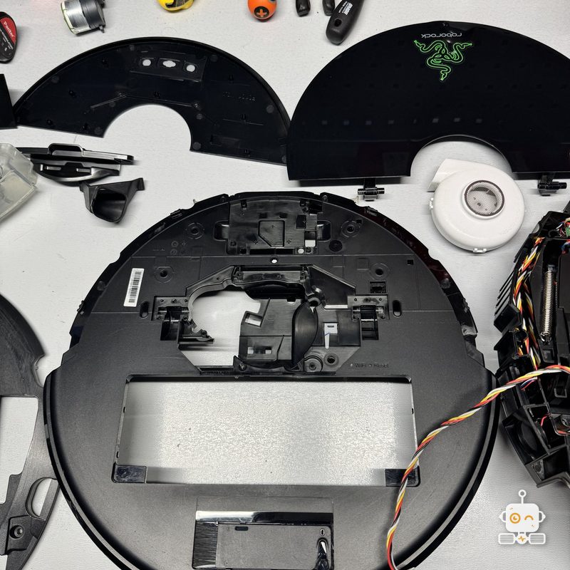 Capacul și carcasa unui Roborock S6 MaxV, desfăcute pentru reparație