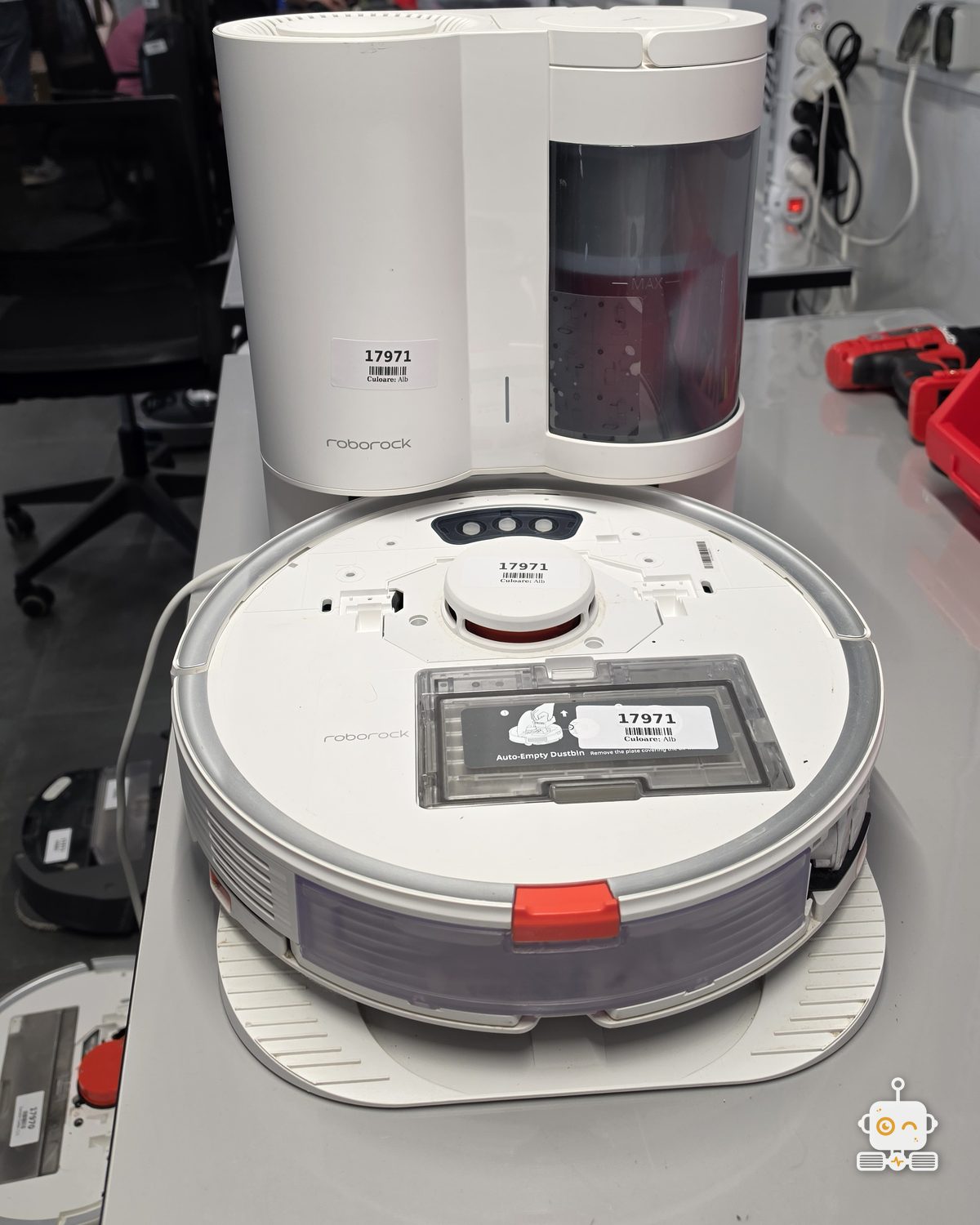 Robot aspirator Roborock cu stația de golire, pe bancul de lucru din atelierul Clinicii Roboților
