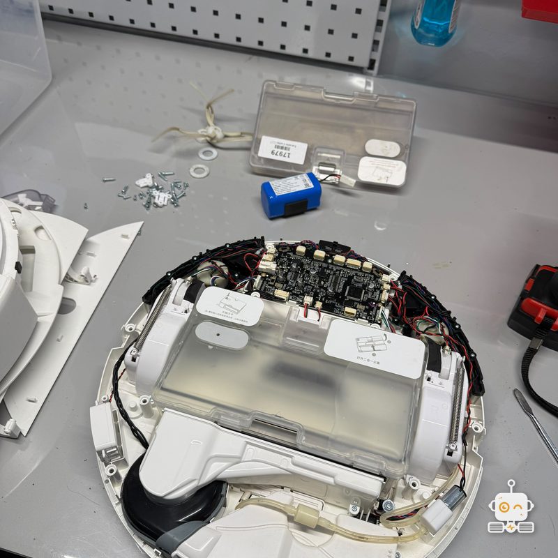 Robot Xiaomi deschis pe banc, cu placa de bază și rezervorul la vedere