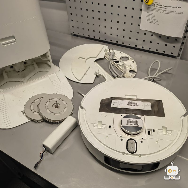 Robot Xiaomi cu mopurile și bateria scoase, pe bancul de lucru