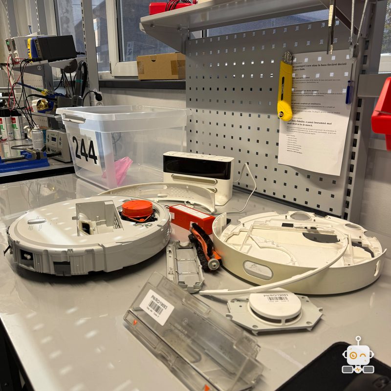 Doi roboți Xiaomi desfăcuți pe bancul atelierului Clinicii Roboților