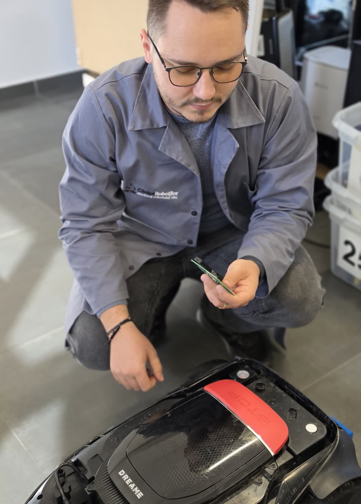 Tehnician Clinica Roboților verifică placa electronică a unui robot de tuns iarba Dreame la revizia de iarnă