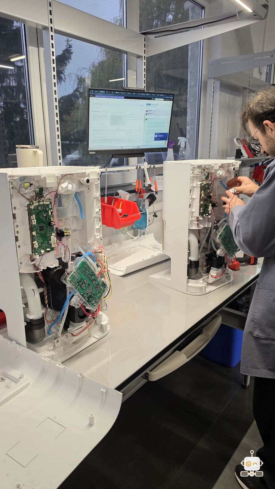 Două stații de robot aspirator Dreame deschise pe bancul de lucru al Clinicii Roboților