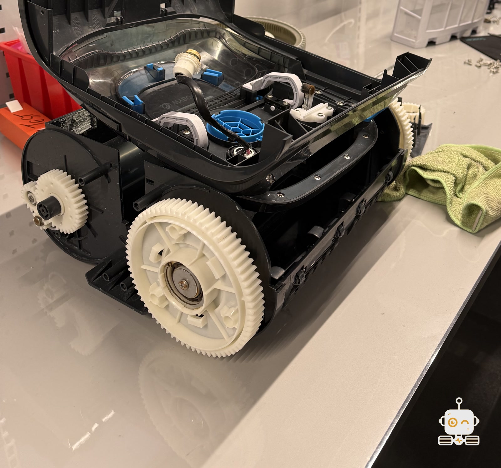 Un robot de piscină desfăcut pe bancul de lucru al Clinicii Roboților